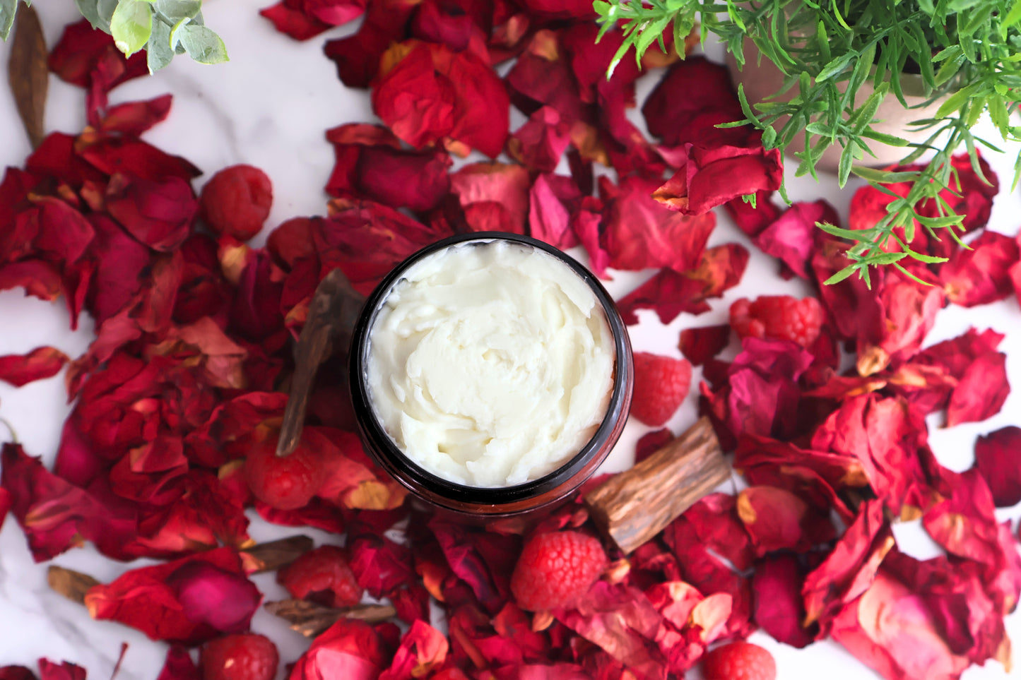 Luxury Nomadic Shadow perfume body butter overhead view showing rich smooth texture and rose petals and oud accents